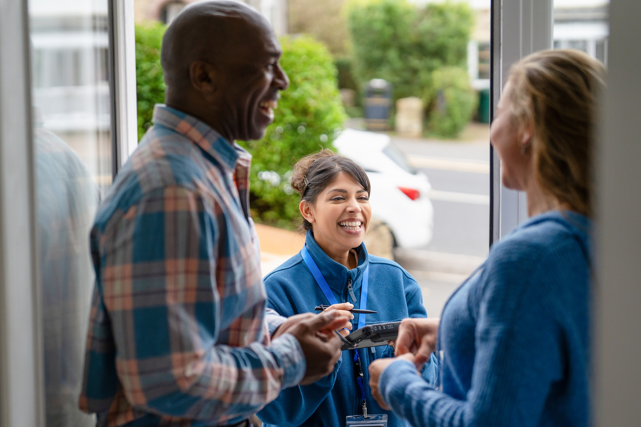 : Young fundraiser confidently speaking with someone at their front door